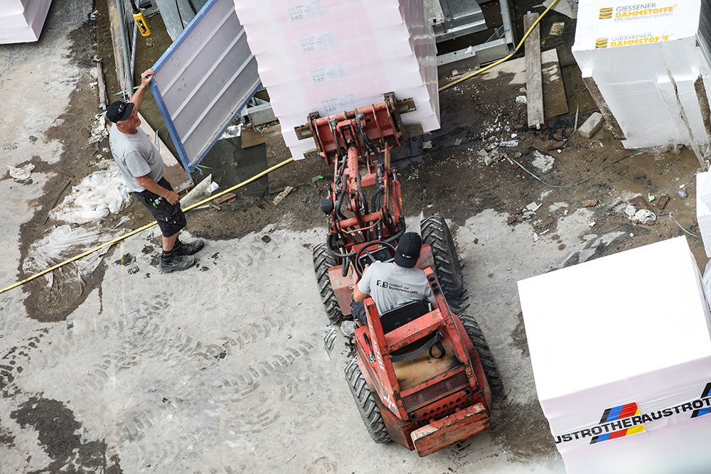 Transport von Dämmstoffplatten mit einem Teleskoplader auf einer Baustelle