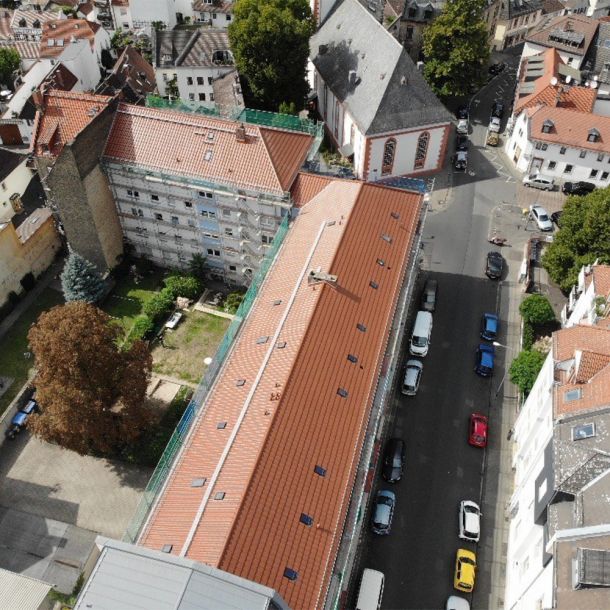 Luftaufnahme einer großflächigen Dachsanierung im historischen Gebäudeensemble
